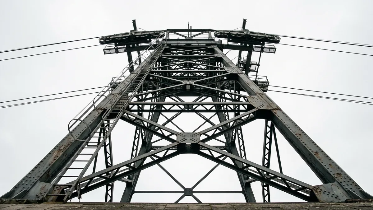 Genietete Stahlstütze einer Seilbahn von unten fotografiert, oben die Rollenbatterien