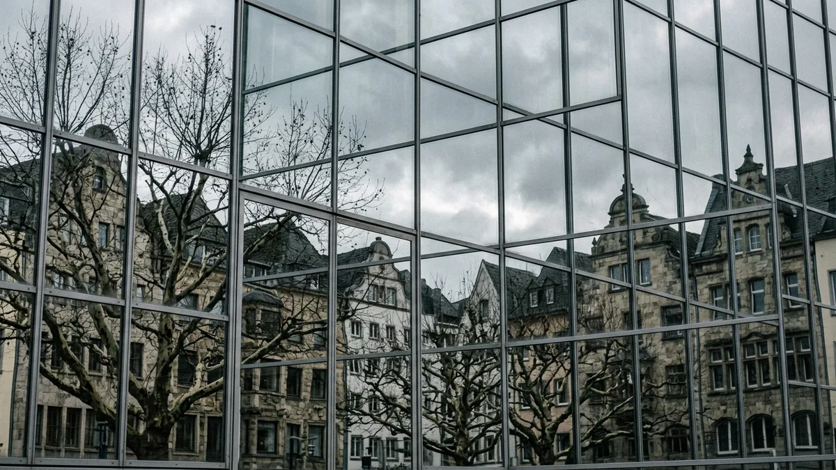 Detail einer Glasfassade am Neumarkt mit gespiegeltem Kölner Straßenbild