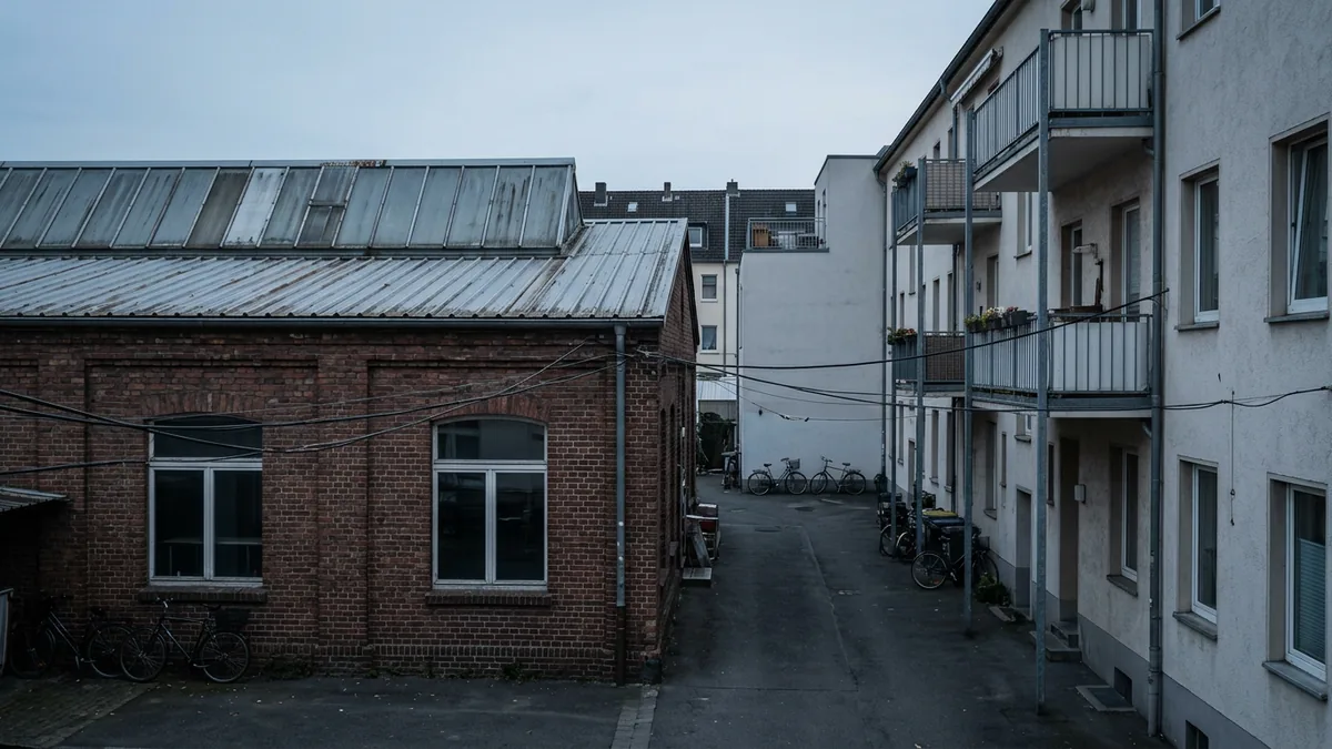 Industriehalle mit Veranstaltungsbetrieb direkt neben Wohnbebauung, Blick aus einem Innenhof